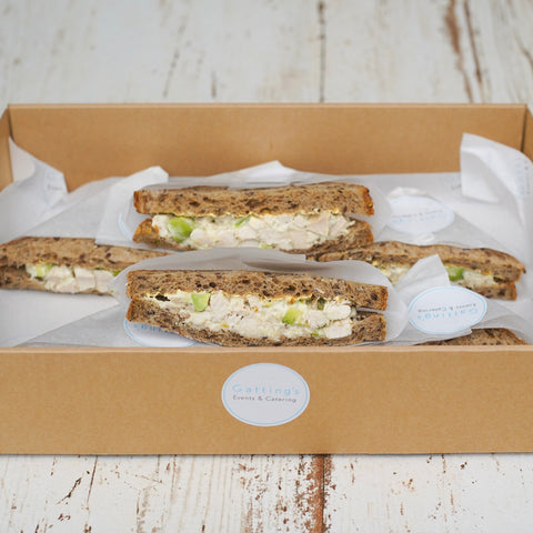 Box of sandwiches with a visible brand label on a wooden surface