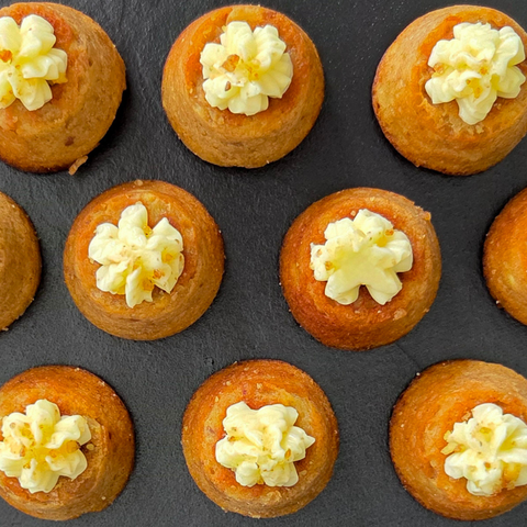 Small pastries with cream on a dark surface