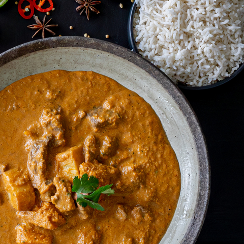 Curry dish with rice on a dark surface