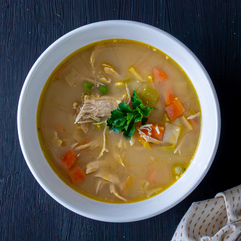  bowl of soup with vegetables on a dark surface