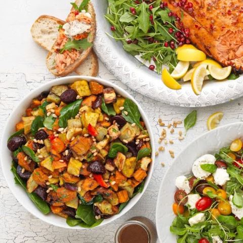 Assorted salads with various ingredients on a white surface