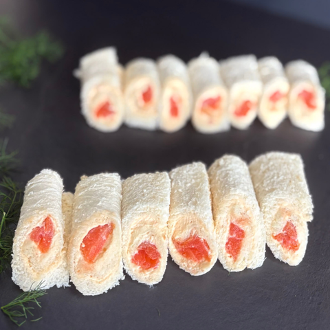 Rolls of food with a red filling on a dark surface