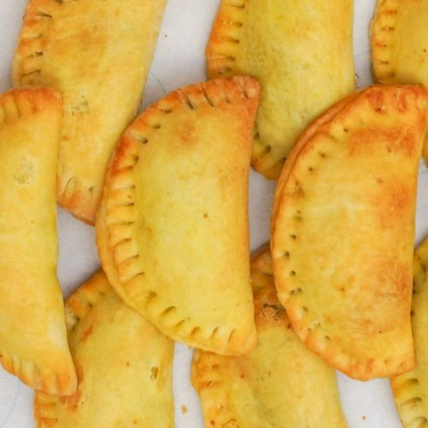 Baked pastries with golden-brown crusts on a white surface