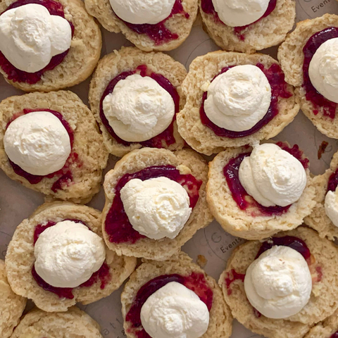 Cookies with cream and jam on a white plate