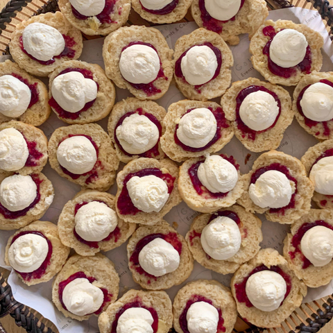 Biscuits with jam and cream on a woven surface